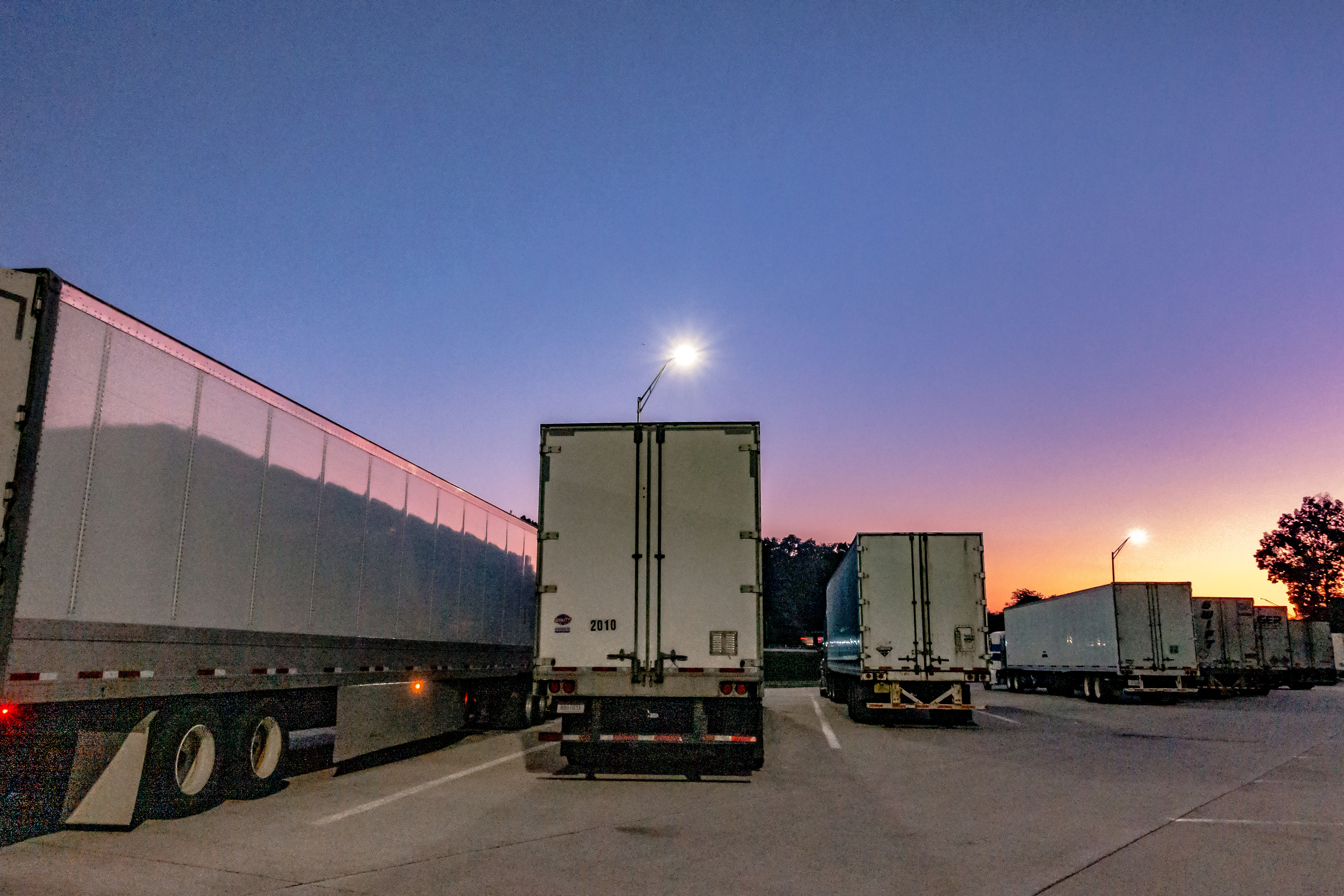 Trucks and trailers at a rest stop at sunset